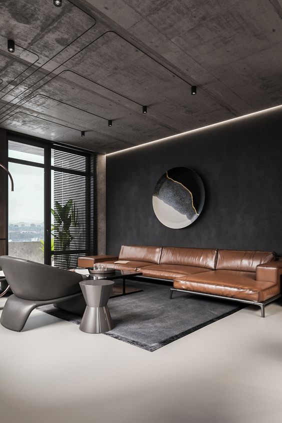 a room with a leather couch and a black wall