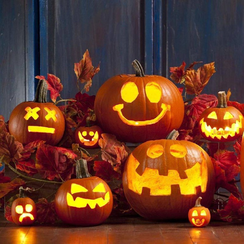 a group of carved pumpkins with lit candles