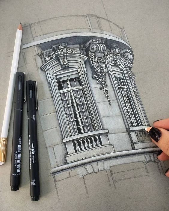 a drawing of a building with a pencil and markers