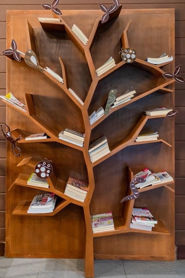 a wooden tree shaped shelf with books