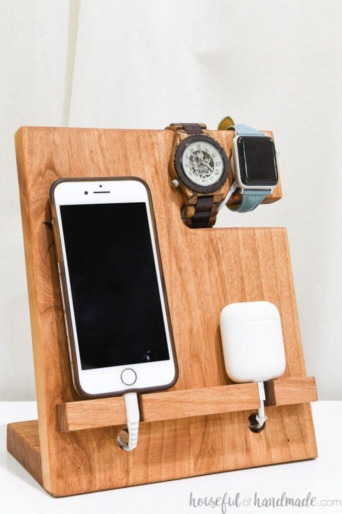 a phone and a charger on a wood stand