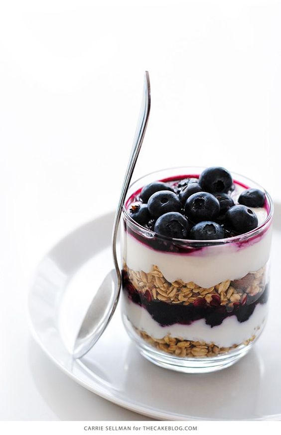 a glass of yogurt with blueberries and oats