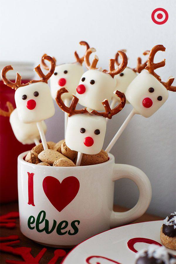 A mug with reindeer shaped marshmallows on it.