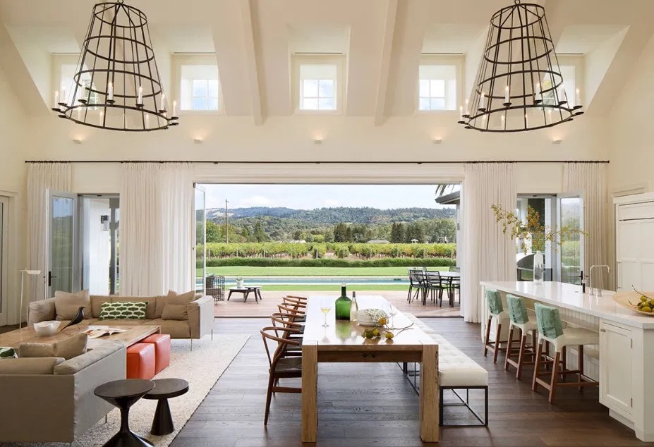 A large living room and dining room with a view of a golf course.