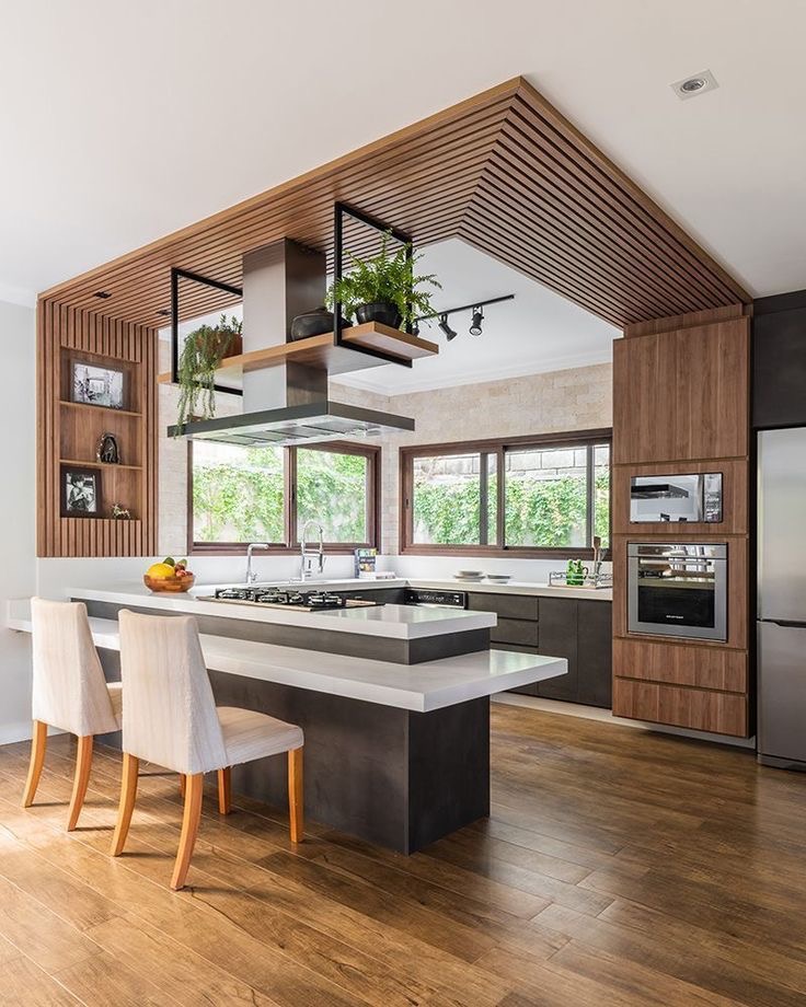 A modern kitchen with wood floors and a wooden island.