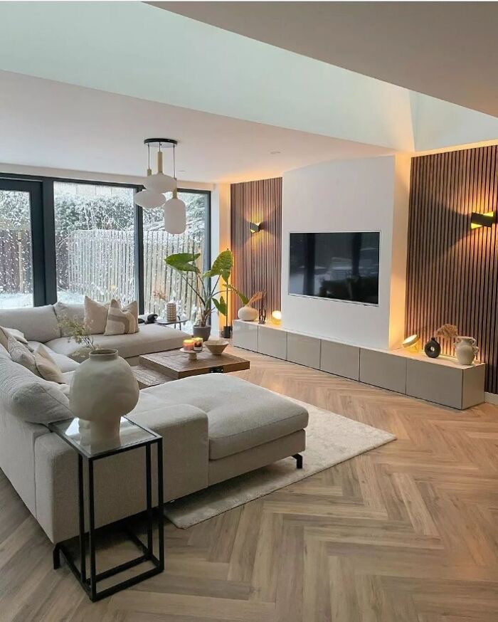 A modern living room with wooden floors and a flat screen tv.