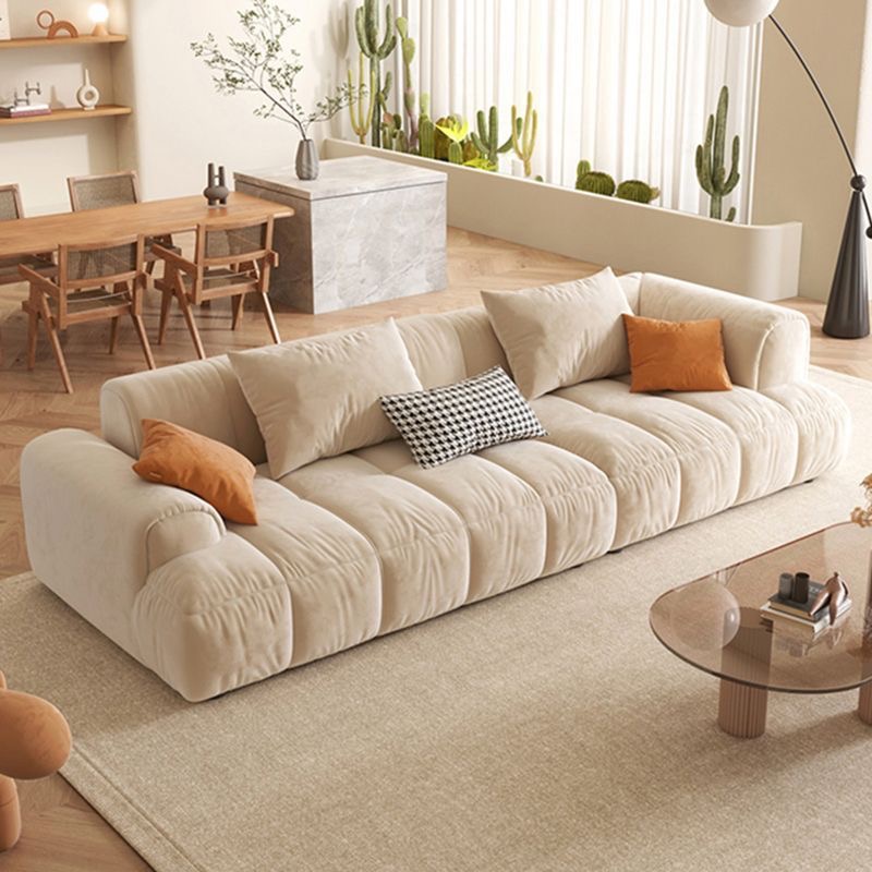 A living room with a beige couch and a coffee table.
