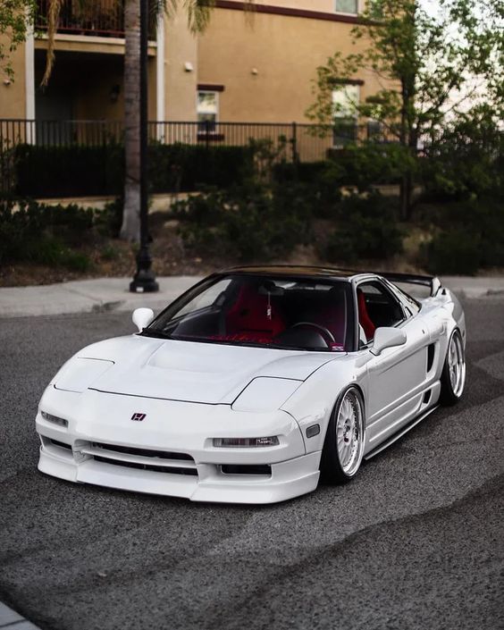 A white honda nsx parked on the street.