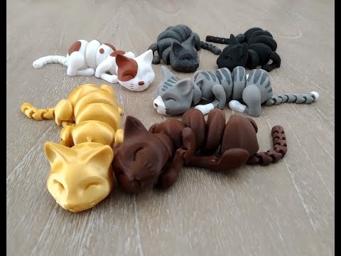 A collection of colorful, segmented cat figurines in various sleeping positions on a wooden floor.