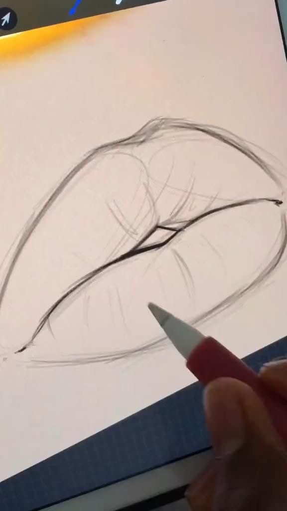 An artist's hand sketching detailed lips with a pencil on a digital drawing tablet.