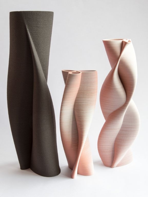 Four twisted ceramic vases in varying heights and soft earth tones, displayed against a plain white background.