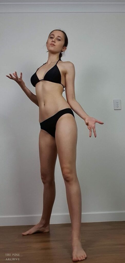 Woman in a black bikini posing gracefully in a minimalistic room.