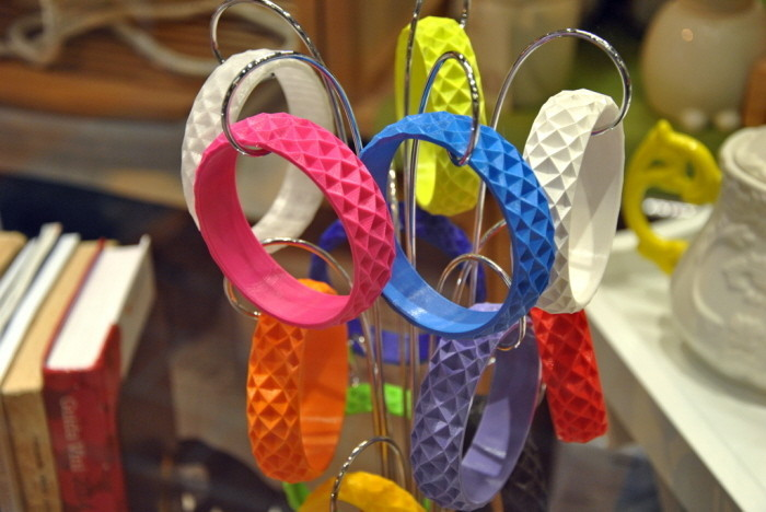 Colorful silicone wristbands displayed on a metal rack, featuring different patterns and textures.