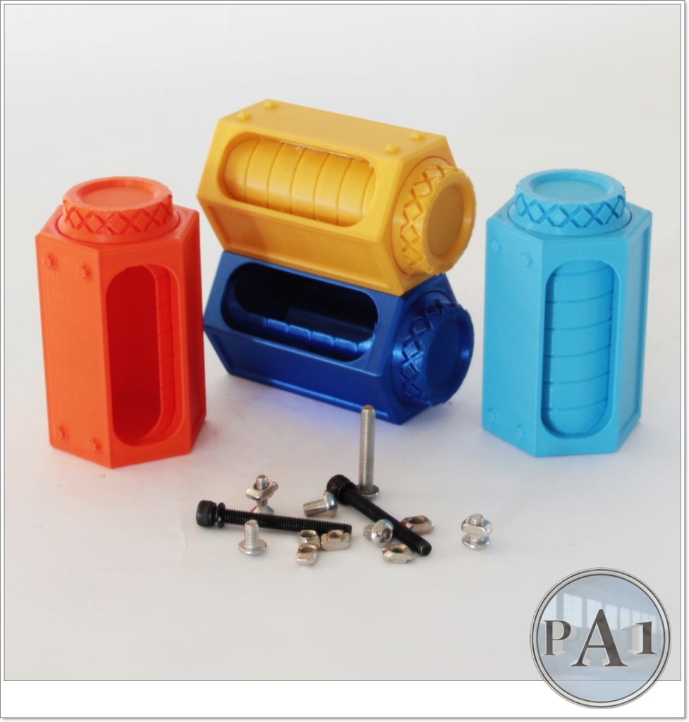 Three plastic 3d-printed objects in red, yellow, and blue shaped like batteries with several screws and nuts in front, displayed on a plain white surface.