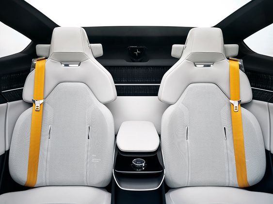 Interior of a modern car with two white seats, yellow seat belts, and a center console. The design is minimalist with a high-tech appearance.