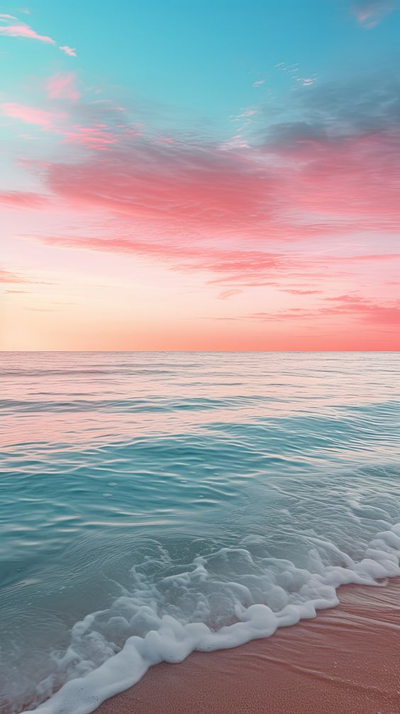 A tranquil beach scene at sunset with gentle waves washing ashore and the sky painted in hues of pink and blue.