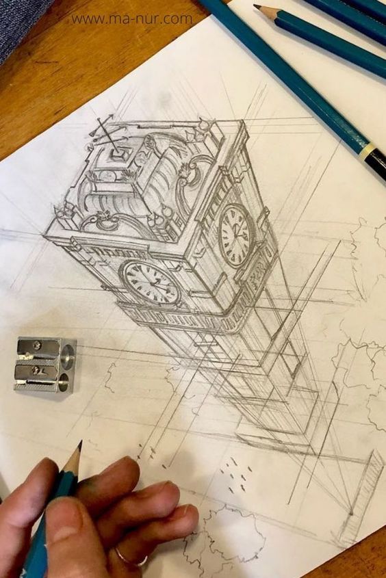 A hand holding a pencil sketches an intricate drawing of a clock tower on white paper. Several blue pencils and a sharpener are placed on the wooden desk.