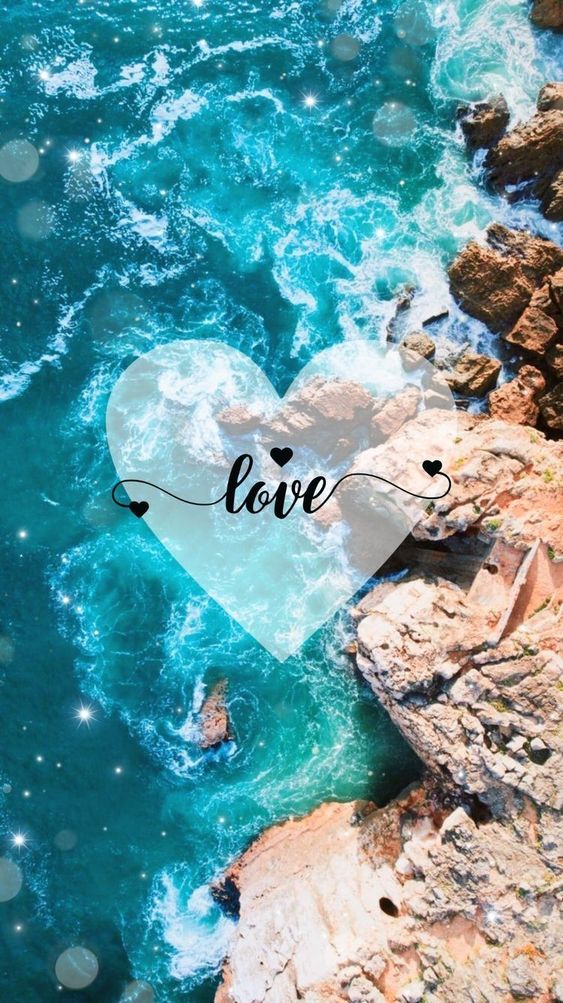 Aerial view of rocky coastline with blue waves crashing. A transparent heart with the word "love" written inside is superimposed over the water.