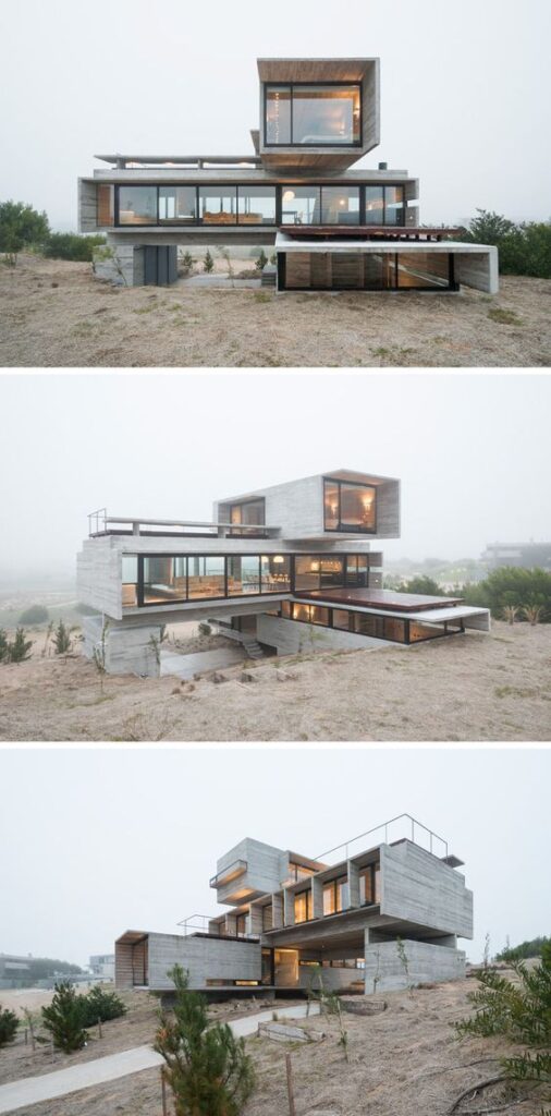 Modern architectural home with large glass windows and overlapping concrete structures in a foggy, rural landscape.
