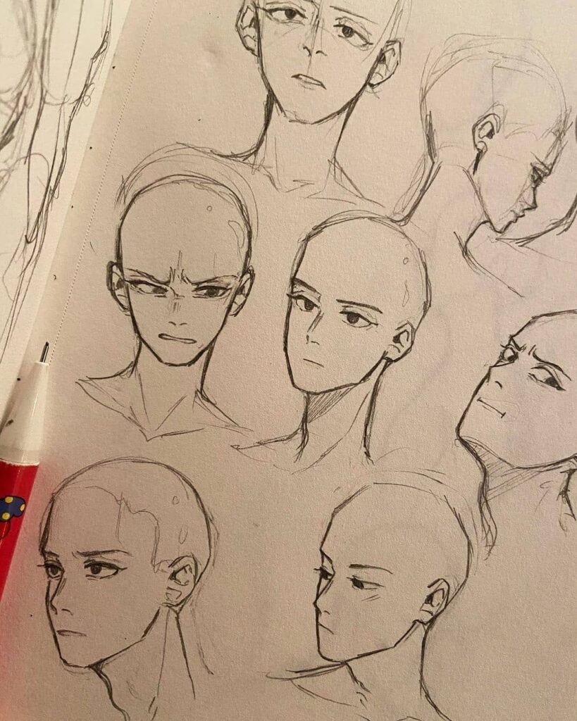 A sketchbook page with numerous pencil drawings of a bald character's head in various angles and expressions surrounding a partially visible pencil.