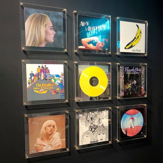 Wall-mounted collection of iconic vinyl records, including albums by Adele, Amy Winehouse, The Beatles, and Prince.