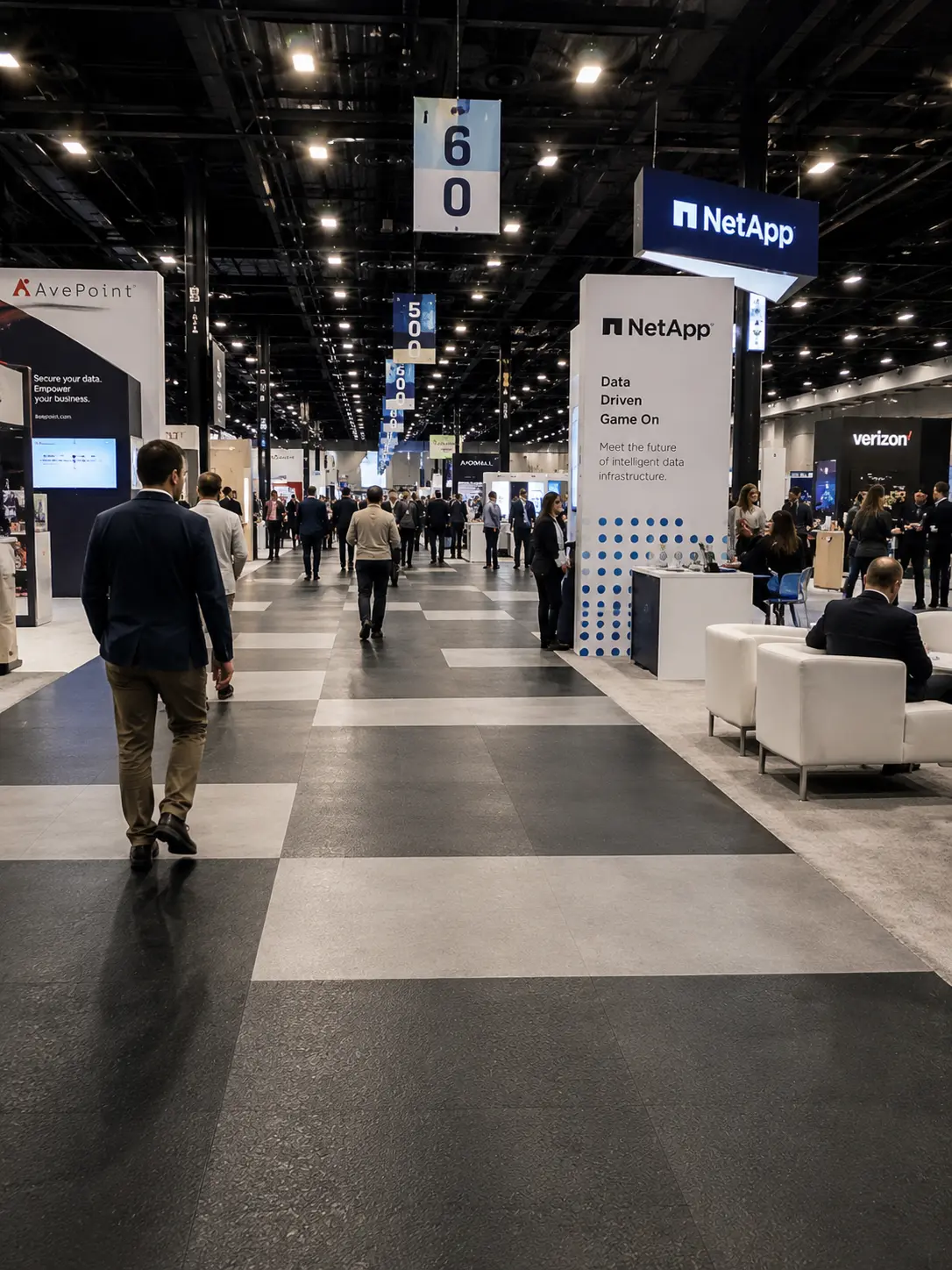 630ceb85-5bfc-499c-b3ce-3716bdffce00 Tech trade show exhibition hall with NetApp booth, attendees walking numbered aisles and networking between booths. | Sky Rye Design Tech trade show exhibition hall with NetApp booth, attendees walking numbered aisles and networking between booths.