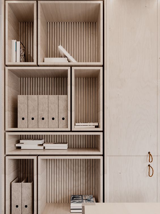 Minimalist wooden bookshelf with books and file organizers in modern home office. Elegant storage solutions for organized workspace.