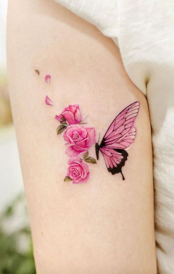 Delicate tattoo of pink roses and a pink butterfly on arm, combining floral beauty and nature-inspired elegance.