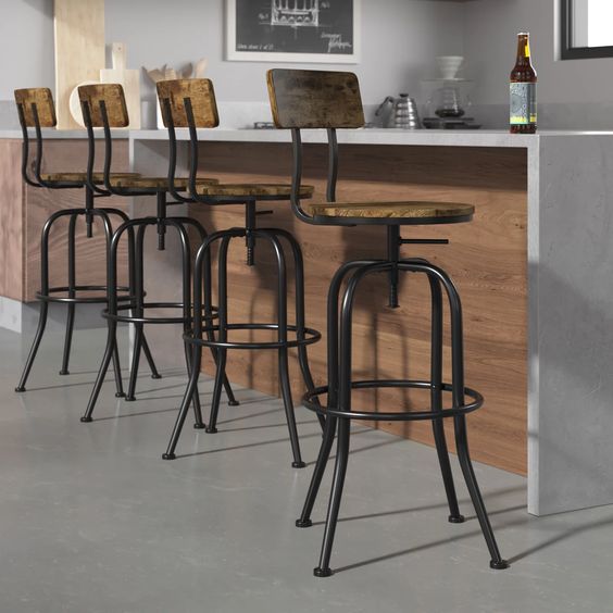 Industrial-style wooden bar stools with metal frames at a modern kitchen island with a white countertop.