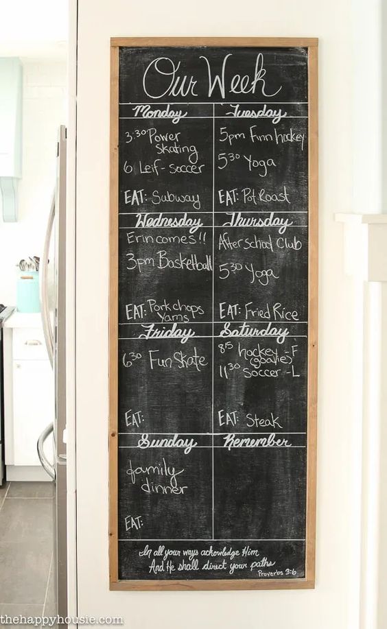 Weekly family schedule chalkboard with activities and meals planned for each day, including sports and family dinner.