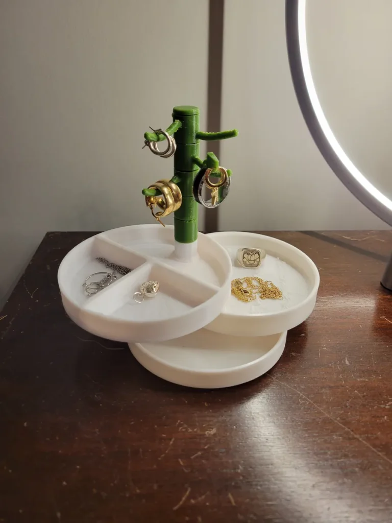 Jewelry organizer with earrings and rings on a white stand, illuminated by a ring light, on a wooden table.