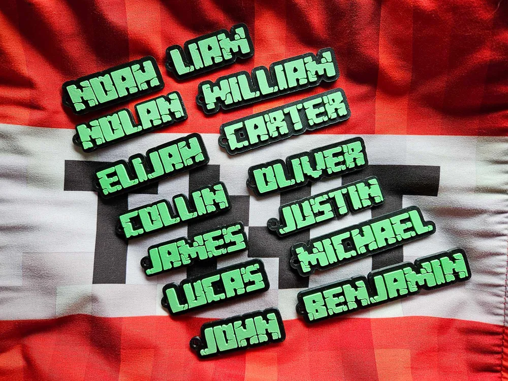 Custom name tags with green and black pixelated text displaying popular boys' names on a red and white checkered background.