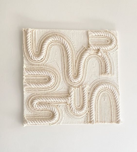 Square macramé wall art with intricate rope patterns and white textured design suitable for modern home decor.