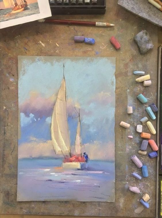 Vibrant pastel painting of a sailboat on the ocean surrounded by art supplies, showcasing nautical and artistic themes.