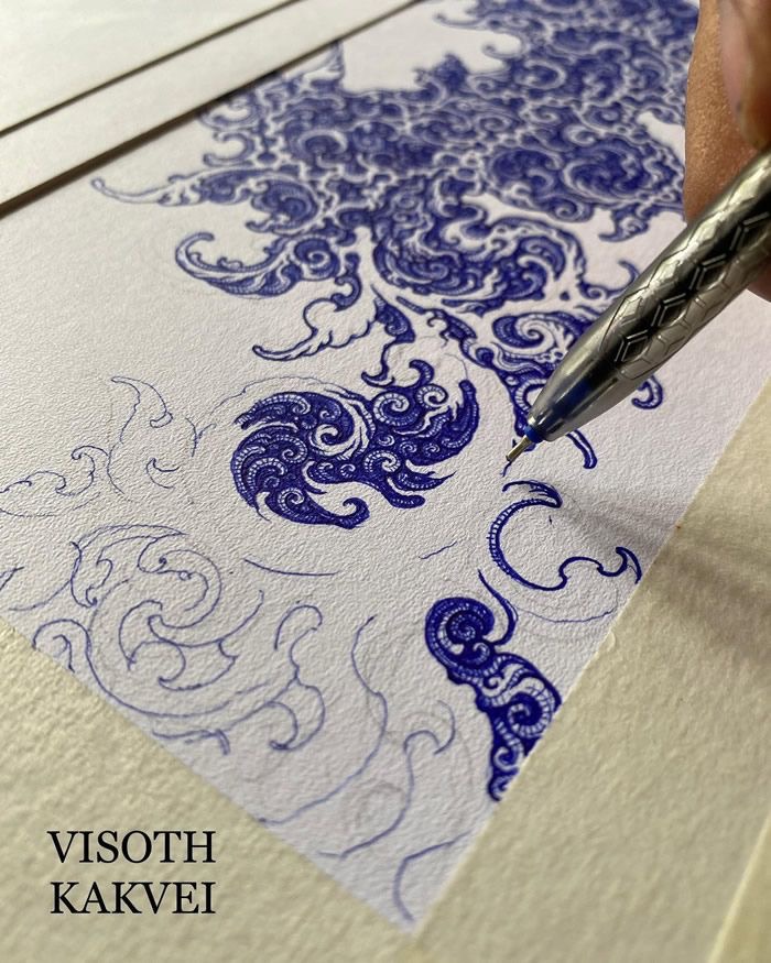 Artist creating intricate blue ink drawing with a detailed pen. Visoth Kakvei's intricate art style showcased.