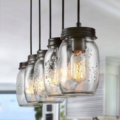 Vintage mason jar pendant lights illuminating a kitchen space with rustic charm and modern industrial design.