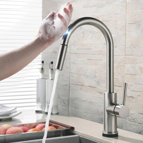 Modern kitchen faucet with soapy hand under running water, highlighting sleek design and stainless steel finish.