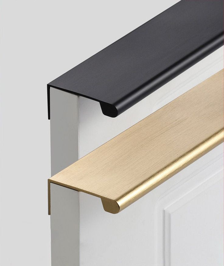 Black and gold modern cabinet handles on a white background, showcasing minimalist contemporary furniture hardware design.