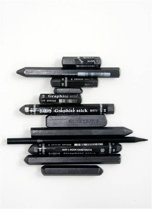 Various graphite sticks and pencils arranged on a white background, ideal for drawing and sketching.
