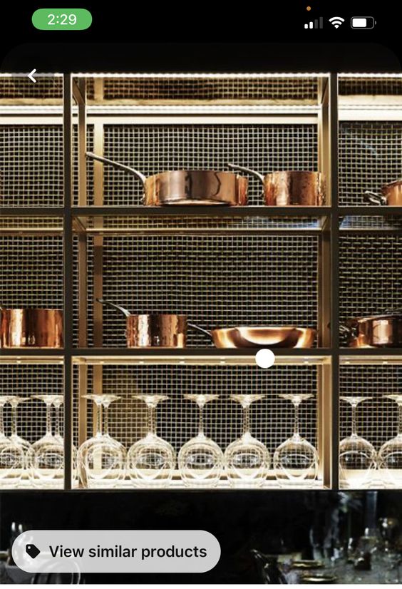 Elegant kitchen shelf display with copper pots and glassware, illuminated showcase. #kitchen #interiordesign #elegance #copper