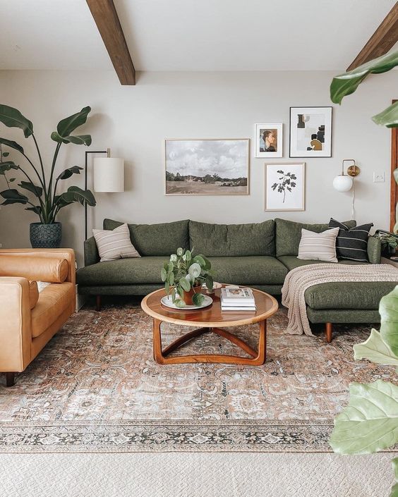 Modern living room with green sectional sofa, cozy decor, and indoor plants. Stylish coffee table on patterned rug.