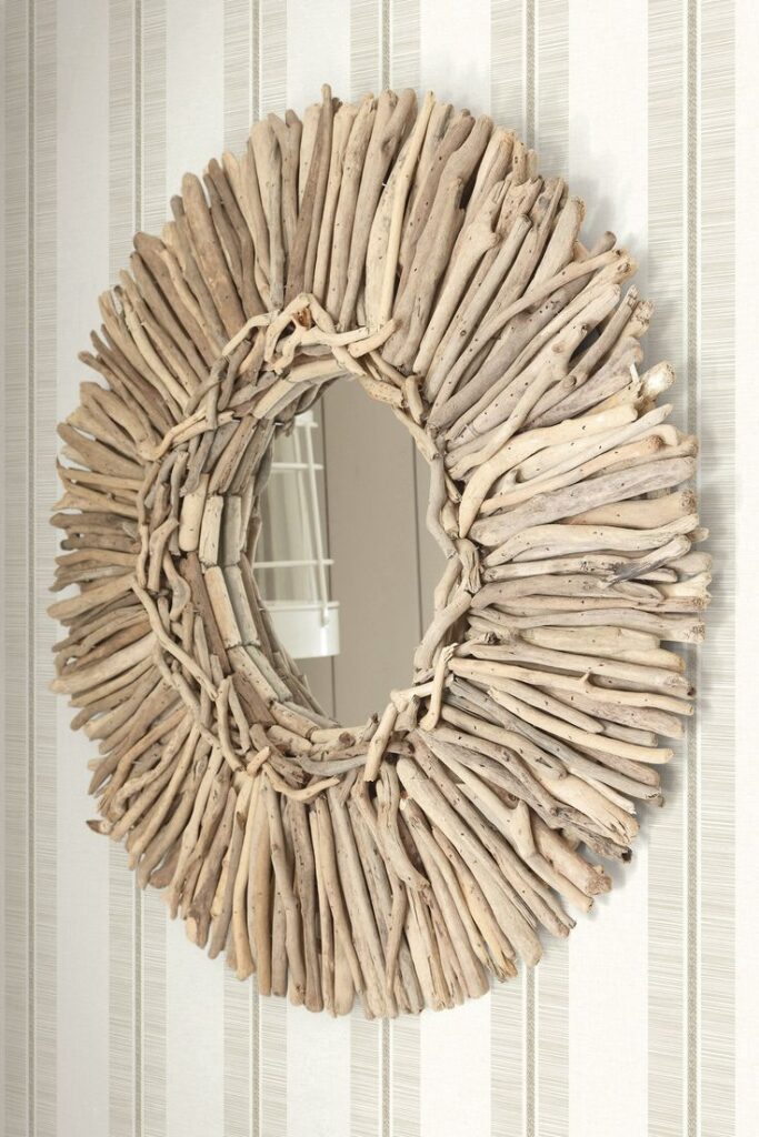 Rustic driftwood wreath mirror on beige striped wall adds coastal charm and natural elegance to home décor settings.