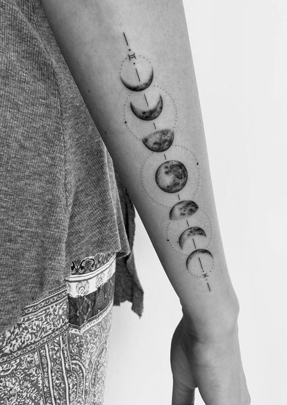 Arm tattoo of moon phases in black ink, showing the lunar cycle from new moon to full moon.