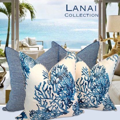 Lanai Collection pillows with ocean and coral patterns in a sunny beachfront room with palm trees and sea view.