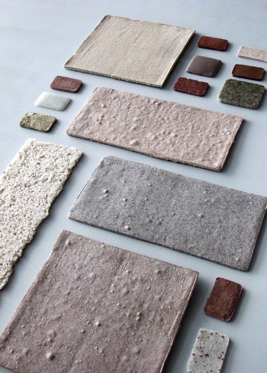 Various textured, colored stone tiles arranged on a white background, showcasing different shapes and sizes for interior design.