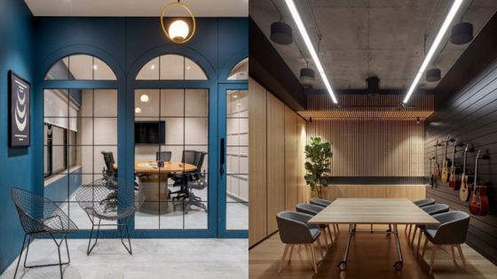 Modern office meeting rooms with blue accents, glass doors, wooden furniture, and hanging guitars on the wall.