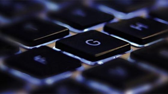 Close-up image of an illuminated computer keyboard focusing on the letter 'G' key with a blurred background.