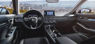 Modern Honda car interior with city skyline view, featuring advanced dashboard, steering wheel, and digital display screen.