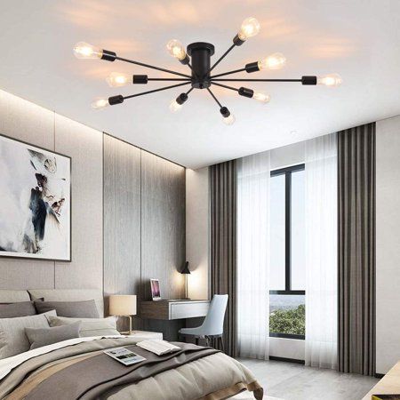 Modern bedroom with a stylish spider chandelier, large window, and a sleek desk area, creating a cozy and elegant atmosphere.