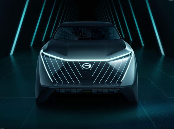 Futuristic electric concept car with illuminated grille and sleek design in a dark, modern tunnel with neon lights.